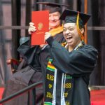 Sociology graduate Addi Nunnelly proudly holds up her diploma cover after walking across the commencement stage on Saturday afternoon