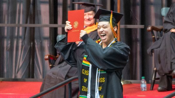 Sociology graduate Addi Nunnelly proudly holds up her diploma cover after walking across the commencement stage on Saturday afternoon