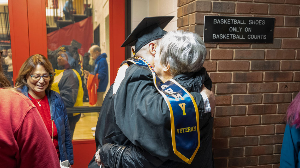 Ryan Manley, an information systems and technology major and the vice president of Triton Vets, gets a huge in the lobby of the Mark Twain Athletic Center after Saturday morning's commencement ceremony.