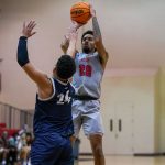 UMSL basketball player Savon Wykle shoots a jump shot over the outstretched arm of a defender