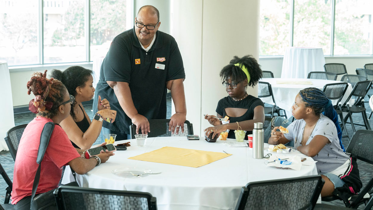 TRIO Student Support Services Director Harry Harris talks to a group of first-generation college students at a welcome breakfast before the start of the fall semester.