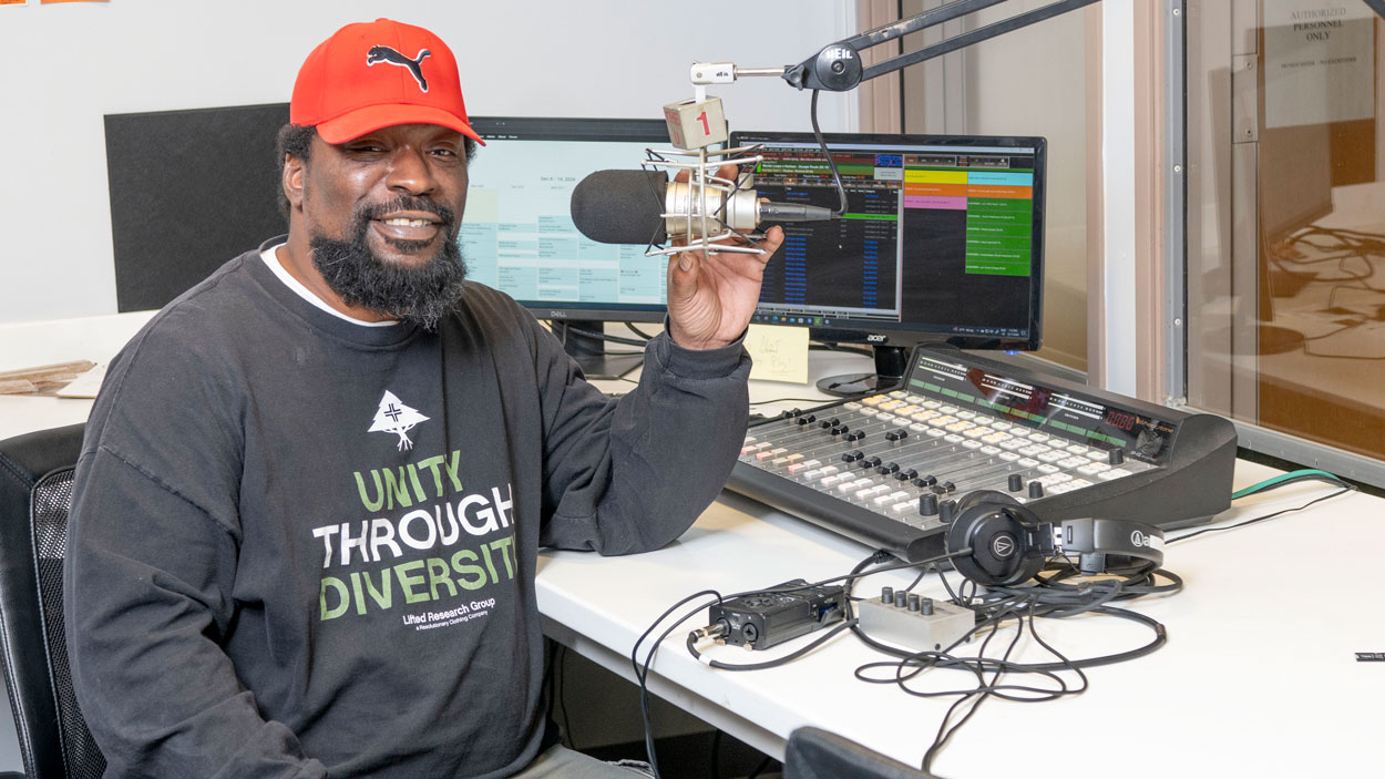 Christopher Brooks sitting at the microphone in the UMSL Radio studio