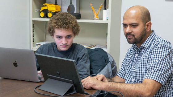 Yosef Granillo and Associate Professor Badri Adhikari discuss edits to a research paper