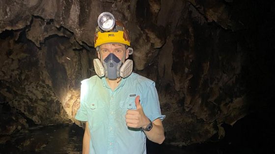 Soren Johnson wearing a helmet and respirator while standing inside La Cueva des las Sardinas