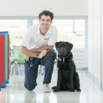 UMSL student Luke Pellegrino poses with Electra, a puppy he is raising for Dogs Inc
