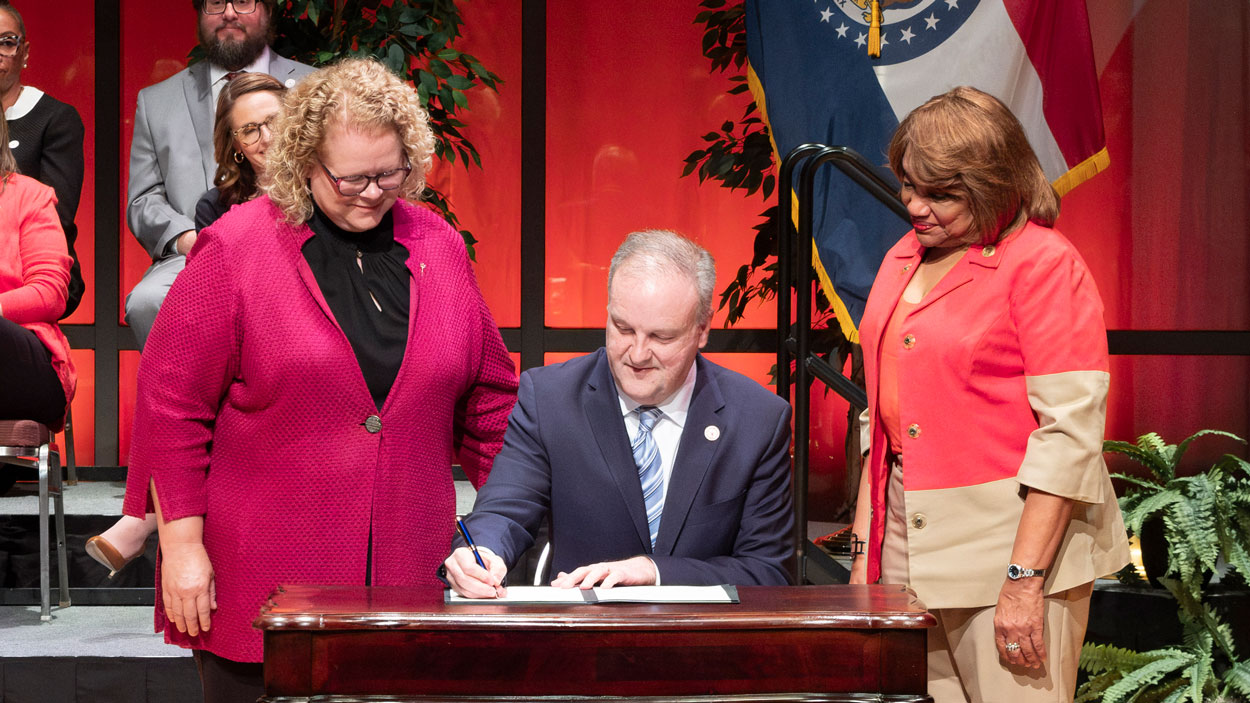 Chancellor Kristin Sobolik and St. Louis County Council Chair Rita Heard Days watch as County Executive Dr. Sam Page signs a bill directing $10 million to support the North County Business and Workforce District being planned on UMSL's South Campus.