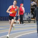 Benjamin VandenBrink runs around the turn during the men's 5,000-meter race at an indoor track and field meet