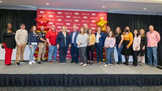 UMSL employees marking their five-year anniversaries stand on stage in the Century Rooms of the Millennium Student Center