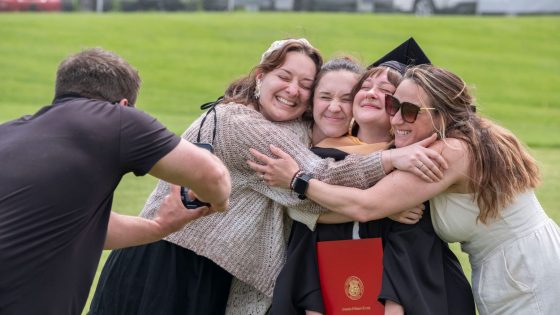 MSW graduate Jory Marcinczyk gets a group hug Saturday afternoon after the commencement ceremony for graduates of the College of Arts and Sciences and School of Social Work.