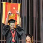 Nursing graduate Spencer Goodson holds up his diploma case after walking across the commencement stage
