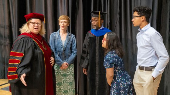 Chancellor Kristin Sobolik speaks with James S. McDonnell Foundation President Jason Purnell and his family before the start of Saturday morning's ceremony for graduates of the College of Arts and Sciences and the College of Nursing. Purnell delivered the commencement address.