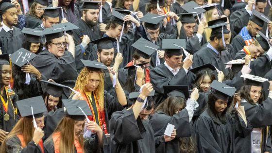 New graduates move their tassels from one side to the other during Saturday morning's ceremony for graduates of the College of Arts and Sciences and College of Nursing