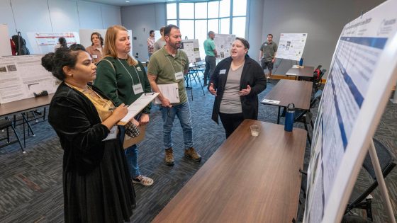 Kel Gruber talking to the judges at the Graduate Research Fair in April
