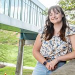 Sophie Heinz standing in front of the MSC Bridge on UMSL's North Campus