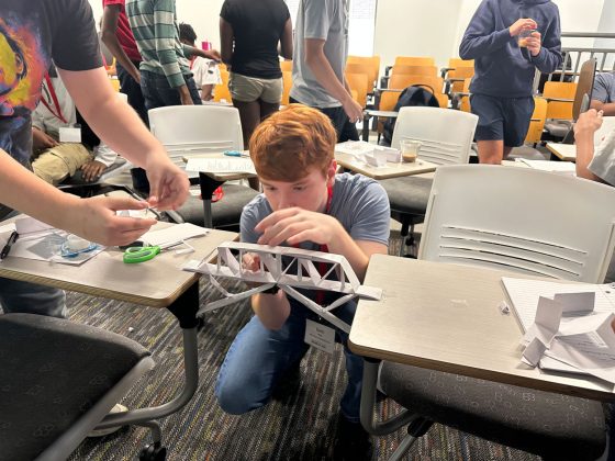 Seth King, a homeschooled student from St. Peters, makes adjustments to his team's paper bridge last Wednesday during a session on structural engineering at the UMSL Engineering Summer Camp.