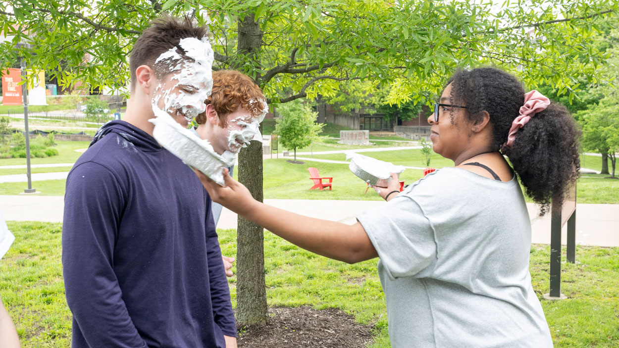 Freshman biology major Kennedy Bright (at right) shoves whipped cream pies in the faces of freshman psychology major Troy Jenkins and junior business administration major Tyler King