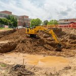 An excavator sits in the middle of a construction site in the Quad on North Campus