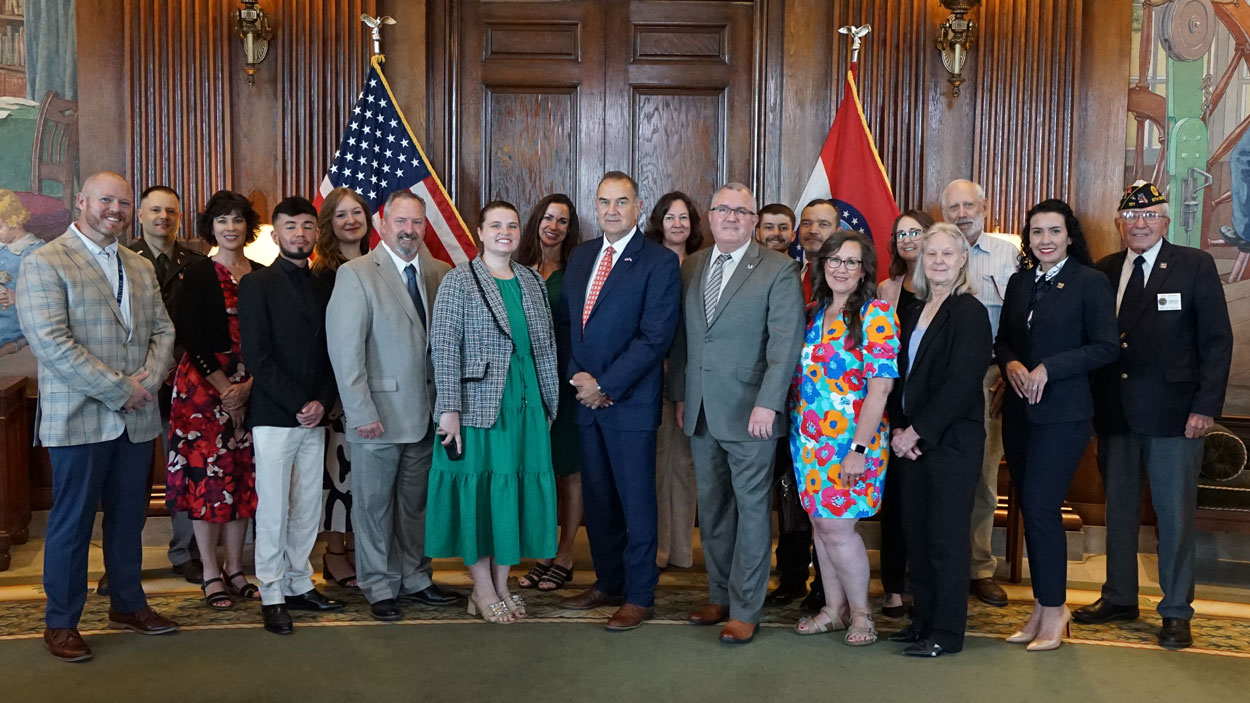 Gov. Mike Kehoe poses with leaders of organizations that are part of the Missouri Governor’s Challenge to Prevent Suicide among Service Members, Veterans, and their Families in his office in the Missouri State Capitol 