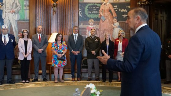 Safer Homes Collaborative Project Director Katie Ellison and MIMH Executive Director Robert Paul stand with other honorees as Gov. Mike Kehoe speaks during a ceremony in his office at the Missouri State Capitol