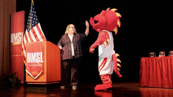 Louie the Triton high-fives Chancellor Kristin Sobolik during the State of the University Address