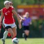 UMSL women's soccer player Josie Maddox dribbles the ball ahead of a chasing defender