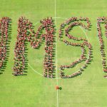 UMSL freshmen pose for a group photo in the shape of UMSL on the soccer field on Aug. 22, 2025
