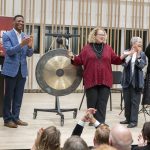 Chancellor Kristin Sobolik bangs a gong to signify the opening of UMSL's new Creative Arts Building on Tuesday night during an open house in the newly renovated space. She was joined on stage by (from left) Provost Steven J. Berberich, Sen. Brian Williams, Associate Professor Pamela Stuerke and Professor Joanna Mendoza.