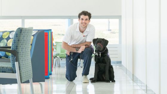 Luke Pellegrino poses with Electra, a guide dog he is training as a puppy raiser for Dogs Inc
