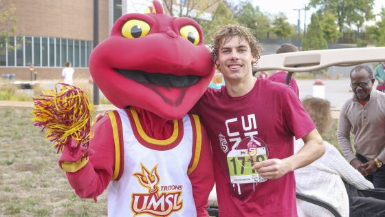 Men's swimmer Mattia Nardi was the top finisher in the UMSL 5K Run and Walk and took a picture with Louie after collecting his prize