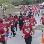 Runners sprint through rain drops at the start of the fifth annual UMSL 5K on Saturday morning on North Campus