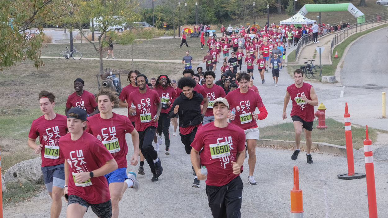 Runners sprint through rain drops at the start of the fifth annual UMSL 5K on Saturday morning on North Campus