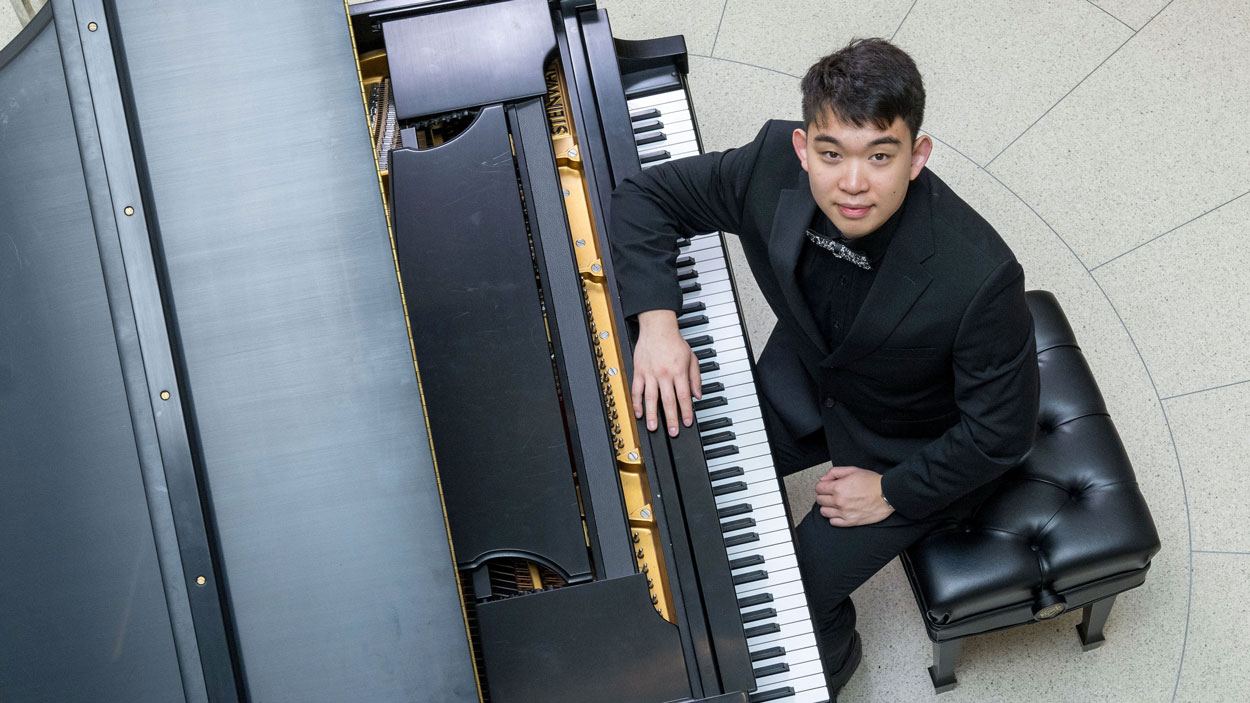 Eric Zhang looks up while seated at a grand piano