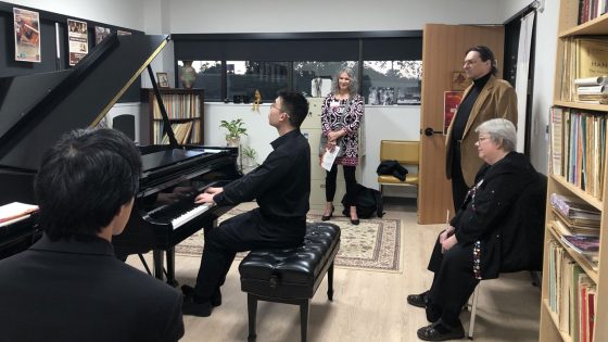 Eric Zhang performs for visitors to Alla Voskoboynikova's office during an open house to mark the opening of the Creative Arts Building on Oct. 21.