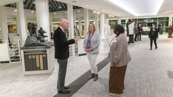 John Neal Hoover, the Executive Director of the St. Louis Mercantile Library Association, speaks with Vice Chancellors Tanika Busch and Tanisha Stevens in the newly created sculpture hall.