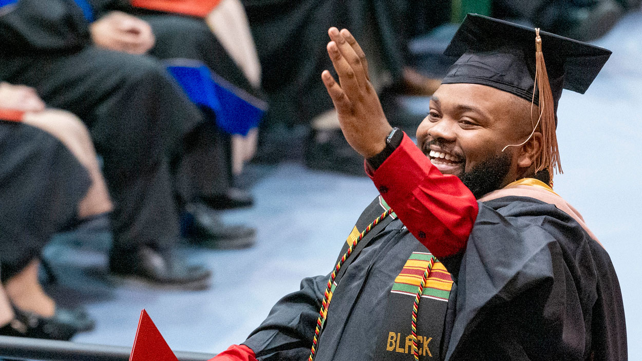 Graduate certificate in Digital and Social Media Marketing and UMSL coordinator of campus traditions and leadship programs, Elijah McCoy, waves to friends and family in the audience
