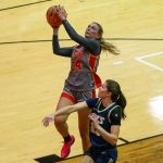 UMSL women's basketball players Morgan Ramthun jumps to shoot a layup over an Illinois Springfield defender
