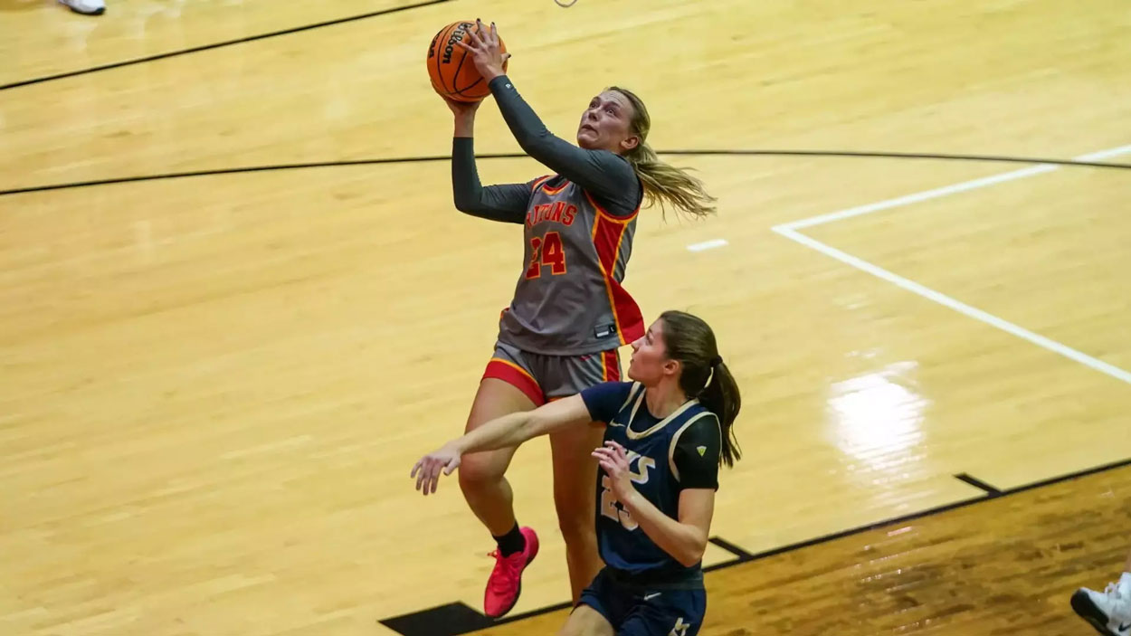 UMSL women's basketball players Morgan Ramthun jumps to shoot a layup over an Illinois Springfield defender