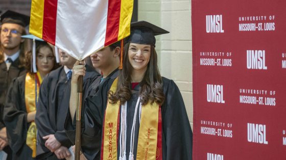 Student marshal Sarah Wirthlin lined up with her fellow students while holding the College of Education banner before Saturday's commencement ceremony