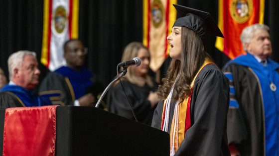 Music education graduate Sarah Wirthlin sings the national anthem during Saturday afternoon's commencement ceremony