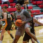 Men's basketball player Demetris Phillips prepares to shoot in front of a defender