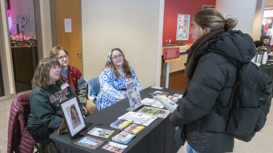 History students Kathleen Jochman, Tyler Winter and Eliza Stengle speak with freshman economics major Josefin Hansson about study abroad opportunities through UMSL while sitting at a table in the 2nd floor rotunda of the Millennium Student Center.