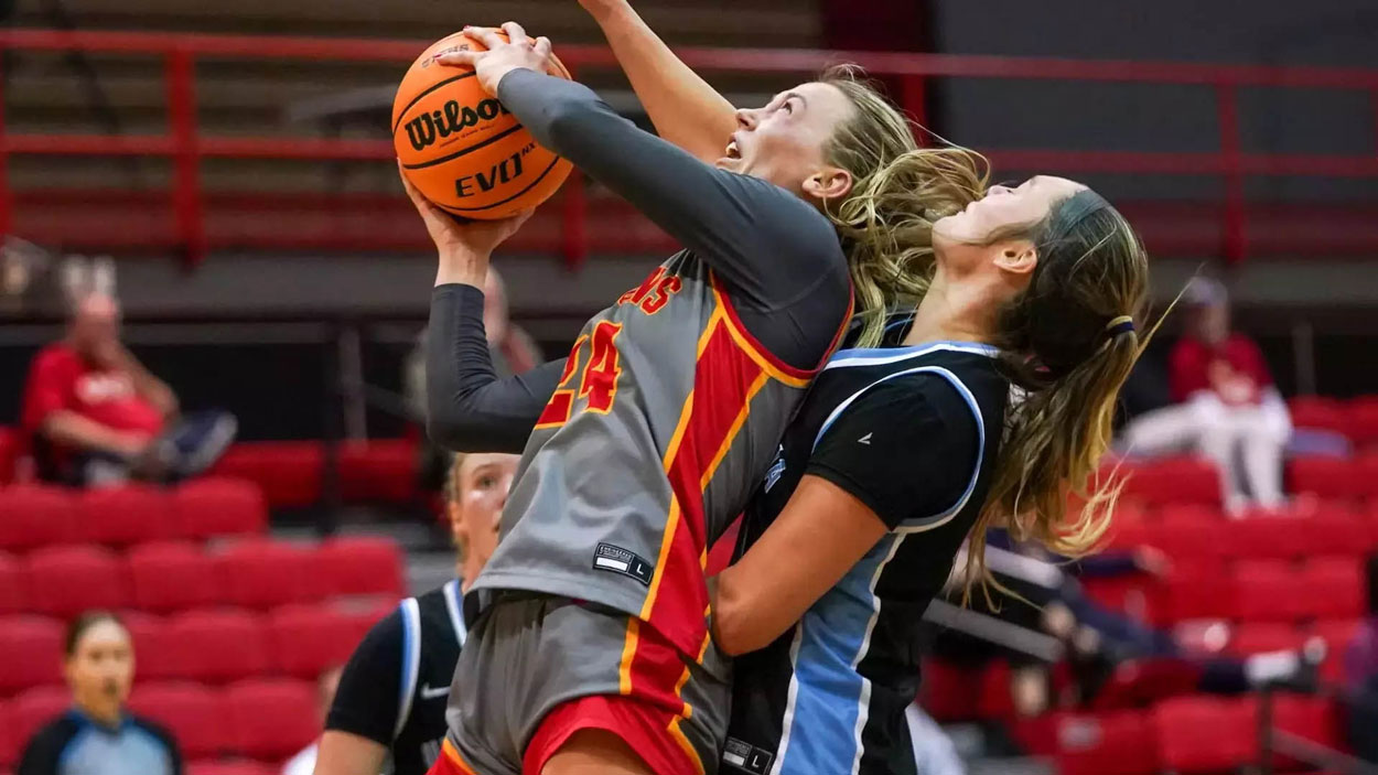 Morgan Ramthun shoots while being closely guarded by an Upper Iowa defender