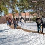 Students walk to class during a snowy day.