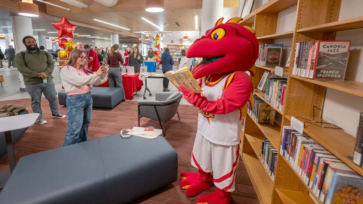 Louie reads a book during an open house for University Libraries