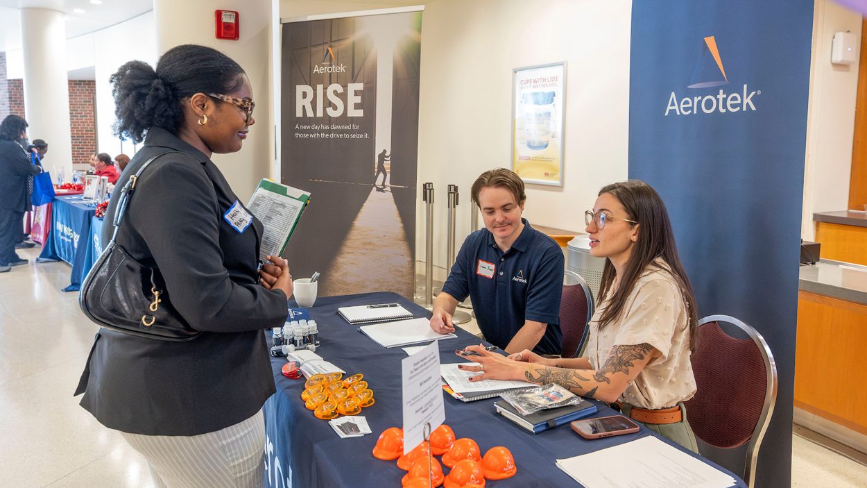 James Purnell and Lexi Stewart, account managers with Aerotek Industrial Staffing, speak with UMSL senior business and finance major, Holly Smith 