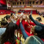 Members of the UMSL women's basketball team huddles on the court before a game