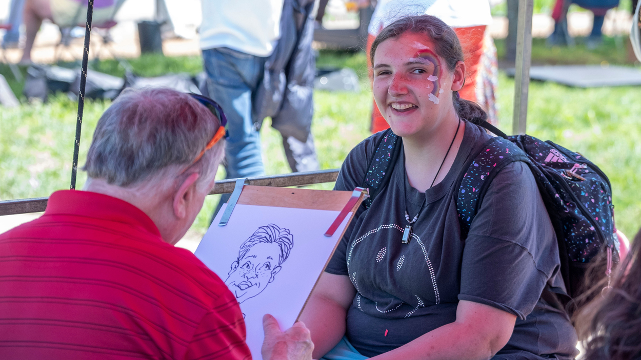 UMSL student, junior child advocacy studies certificate student, Jamie Hahn, gets a caricature done. 