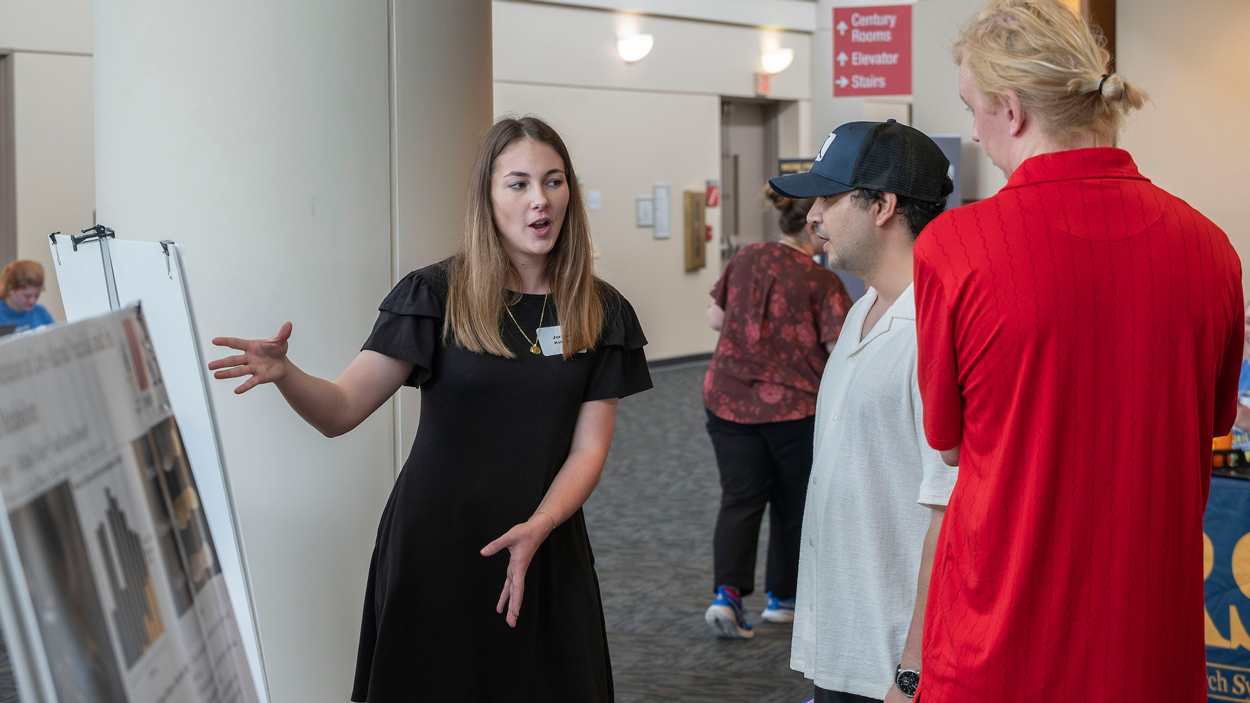 UMSL senior biologyl major, Jordan Kolinski, talks about her research titled "Tarantulas Can Use Black and White Cues in a Discrimination Learning Task" with graduate student Samir Kuinkel and junior Biology major Kory Anthony-Petter.