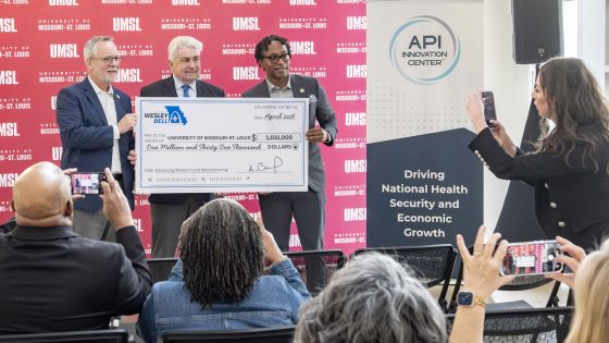 Congressman Wesley Bell presents a ceremonial check to UMSL Vice Chancellor Chris Spilling and API Innovation Center President and Chief Operating Officer Kevin Webb at a media event