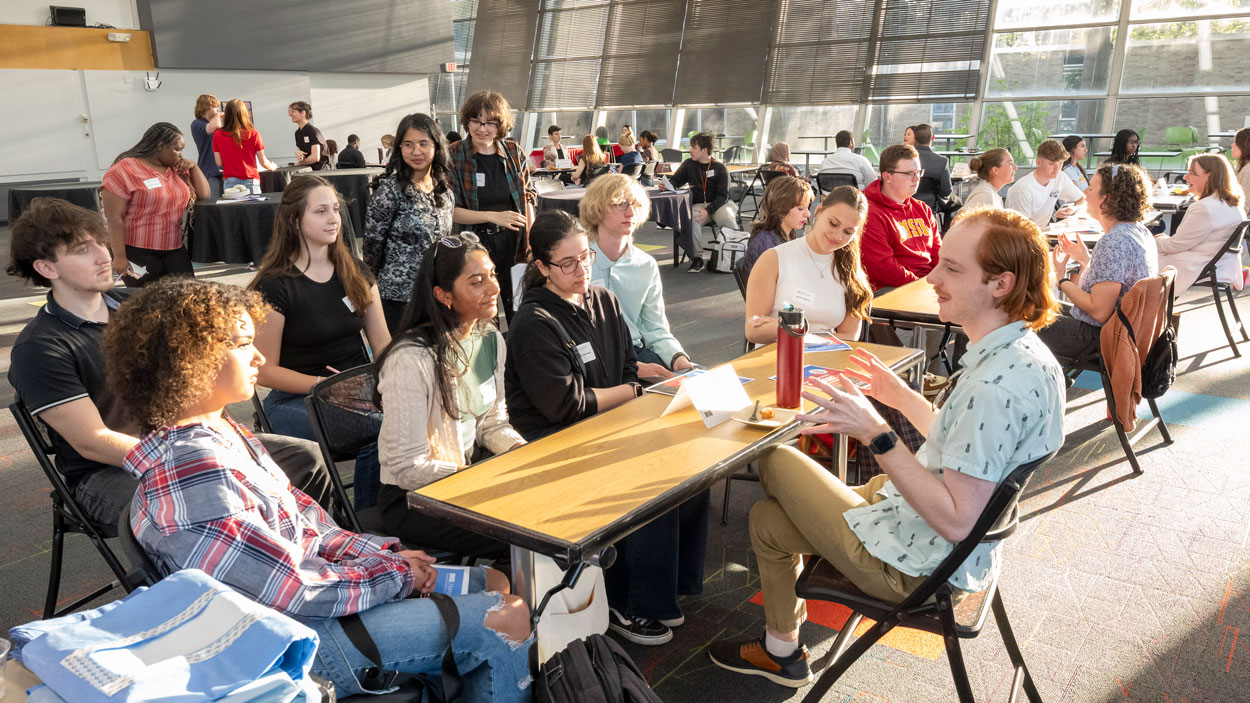 UMSL alum Matthew Lucy speaks with current students in the Pierre Laclede Honors College during a professional development reception in the Ed Collabitat on April 16